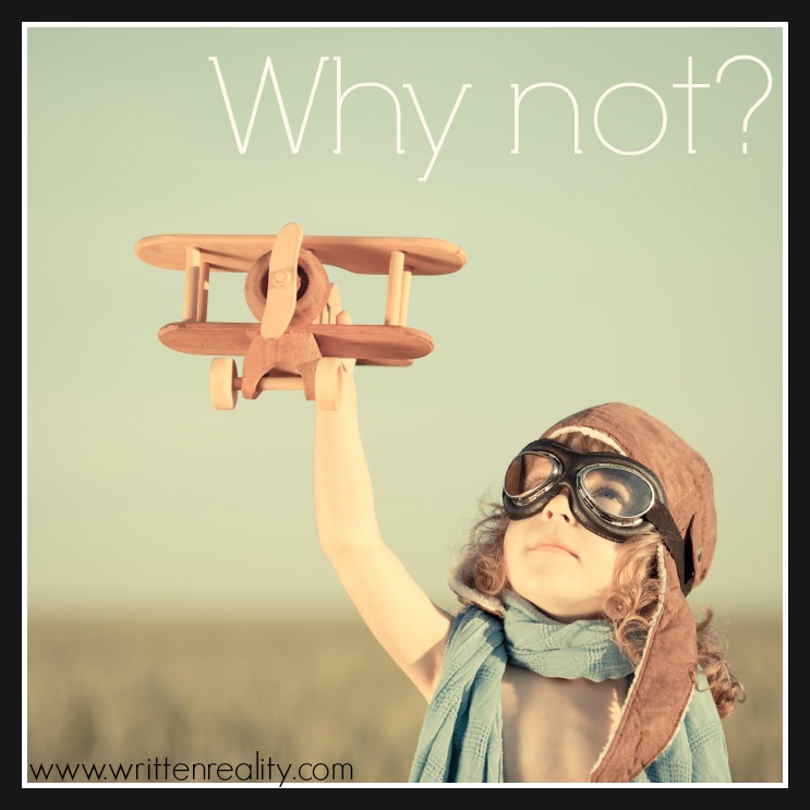 Happy kid playing with toy airplane against blue summer sky background.